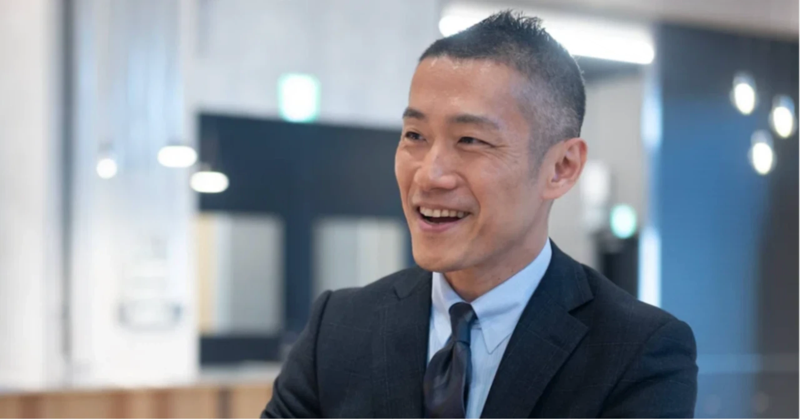 スーツ姿で笑顔を見せる元サンコー取締役社長の有薗悦克さん